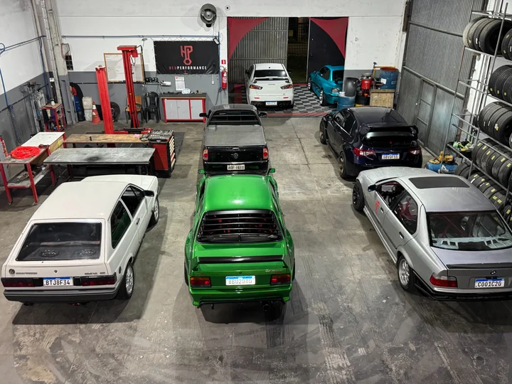 The HeuPerformance garage, with cars, a lift, tools and a tire rack.