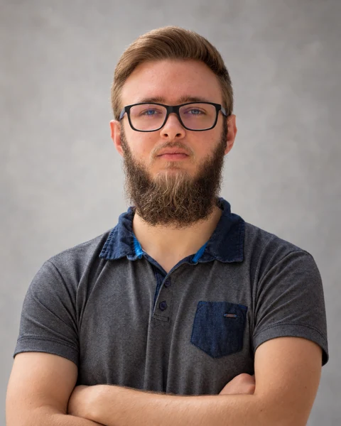 Portrait of Yuri Heupa wearing glasses and a dark polo shirt.